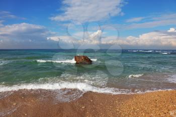 Huge stone in surf waves. Picturesque coast Mediterranean sea, Israel
