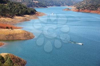 Motor boats and boats in the azure water of the river Merced in early autumn