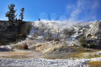 Spring wind above smoking volcanic lake in Yellowstone Park