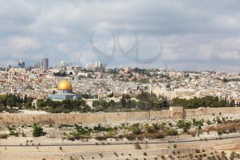  A gold dome and blue walls of a Muslim mosque and a modern city with skyscrapers. Majestic panorama of ancient Jerusalem.