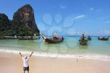 Happy man joyfully welcomes the sunrise. A picturesque ocean bay in the Thai gulf