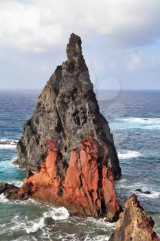 Windy day on the ocean island. Bright red and gray cliffs east of the island