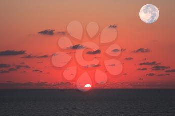 Fantastically beautiful sunset on the Mediterranean Sea. At the same time see the sun and the moon