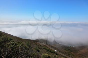 Morning fog at hilly coast of Pacific ocean 