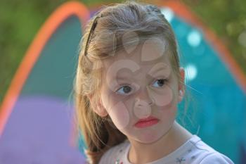  The small serious girl plays to a garden