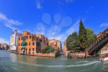 Wonderful holiday in Venice. Ornate facades perfectly restored antique palaces lit setting sun. Graceful bridge spans the Grand Canal.  Photo making the lens Fisheye