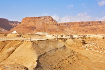 The tourist on edge of a dry picturesque canyon in desert near to the Dead Sea