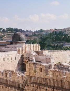 Gray dome of the Al-Aqsa Mosque on the Temple Mount in Jerusalem. The ancient walls of Jerusalem, lit morning sun.