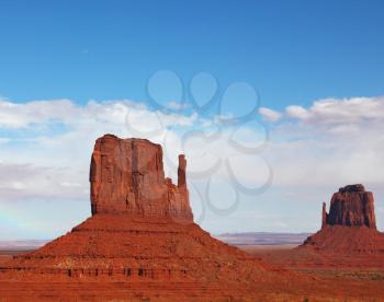 The famous Mittens in Monument Valley. The cliffs of red sandstone at sunset