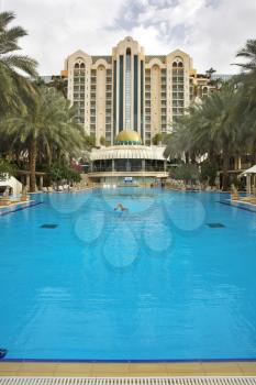 The girl floats in pool of magnificent hotel in the south
