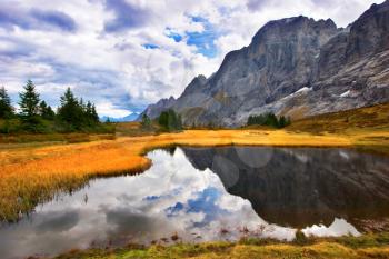  Small fine and smooth lake in the Swiss Alpes, reflecting mountains