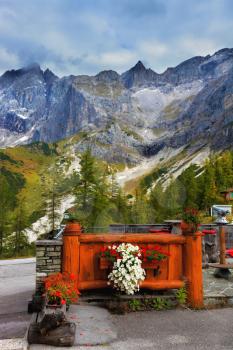 Majestic Austrian Alps. Fence cozy cafe is decorated with flowers