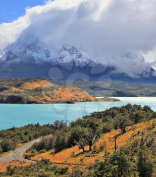 Cold summer in Chile. The National Park Torres del Paine - the emerald waters of the Rio Serrano and snowy peaks  Los Cuernos