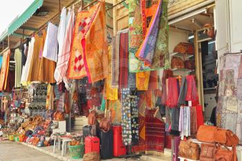 Variegated colors of oriental bazaar. The Arabian market in Jerusalem - bright motley fabrics and clothes are hung out for sale
