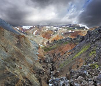 July in Iceland. The famous Valley Landmannalaugar. Multicolored rhyolite mountains with the remnants of last year's snow