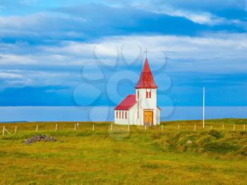 White Chapel. Chapel with red roof on lonely shore of the northern fjord in Iceland
