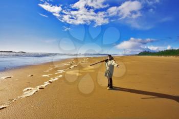 The woman-photographer with photographic equipment in hands on coast of ocean