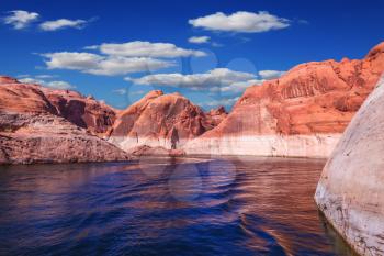  Lake Powell is surrounded by magnificent red hills.   Walk on the boat at sunset. Scenic huge artificial water basin of the Colorado River, USA