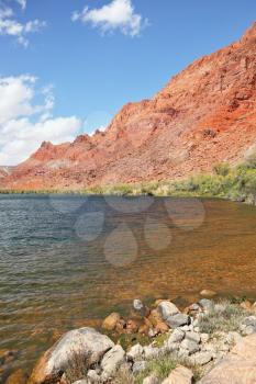 Clean and clear water of the Colorado River among the steep mountains of red sandstone.