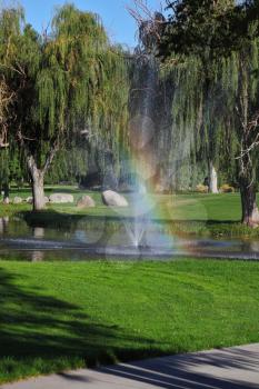 Decorative fountain and shining rainbow on the golf course