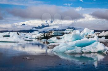 Ice lagoon in July. Summer vacation in Iceland. Icebergs and ice floes are reflected in the mirrored water of the ocean Bay