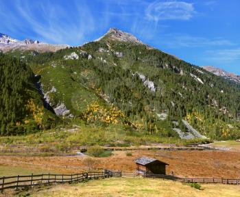 Farmers alpine meadows blocked by low wooden fences. The beautiful autumn day in the Austrian Alps