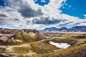 The magic of summer in Iceland. Unmelted snow in the valley among the yellow tundra
