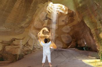 Yoga classes in the cave Beit Guvrin. Woman in white welcomed ray of sunshine. Israel