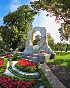 Elegant marble arch frames the bronze statue of Johann Strauss. Wonderful park in the center of Vienna