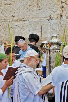 JERUSALEM, ISRAEL - SEPTEMBER 20, 2013: The Western Wall of the Temple in Jerusalem. Many religious Jews in traditional white robes tallit gathered for prayer. Morning Sukkot