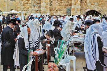 JERUSALEM, ISRAEL - SEPTEMBER 20, 2013:The Western Wall of the Temple in Jerusalem. Morning Sukkot. Many religious Jews in traditional robes tallit gathered for prayer.
