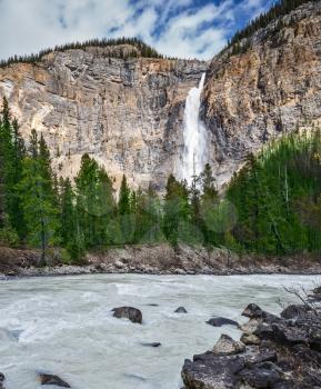 Sunny autumn day in Yoho National Park. Grand Falls Takakkou formed by melting glacier Daly