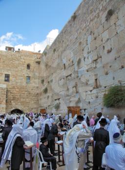 JERUSALEM, ISRAEL - SEPTEMBER 20, 2013:The Western Wall of the Temple in Jerusalem. Morning Sukkot. Many religious Jews in traditional robes tallit gathered for prayer.