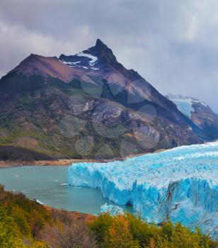 Colossal Perito Moreno glacier in Lake Argentino, surrounded by mountains. Los Glaciares National Park. Sunny summer day