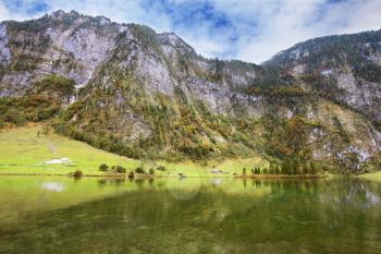  Clouds and mountains reflected in the water. Cloudy day in the Bavarian lake Koenigssee