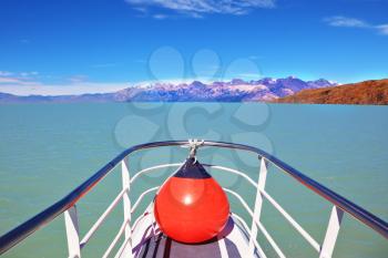 Excursion on the tourist boat on Lake Viedma.  White-blue huge icebergs float near a ship board. Ice and sun Patagonia