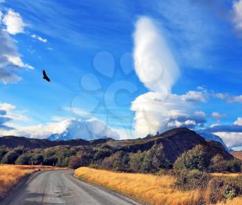 The impressive cloud over Patagonia. Amazingly beautiful sunset illuminates the distant mountains and the dirt road with bright light