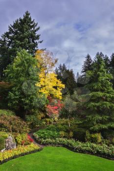 Flower beds of colorful flowers and walking paths for tourists. Butchart Gardens -  gardens on Vancouver Island. The world-famous masterpiece of park architecture