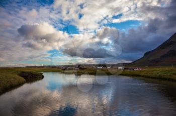 Quiet summer evening on the coast of Iceland. Small pond in the fishing settlement of Arnastapi
