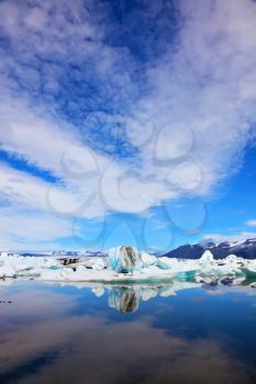 Jökulsárlón Glacial Lagoon in Iceland. Cirrus clouds and spectacular icebergs are reflected in the ocean lagoon