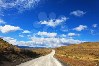 Magic country Patagonia. Gravel road between the mountains. National Park Torres del Paine in Chile