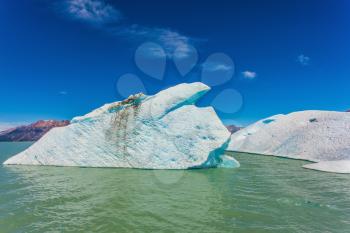  The huge white-blue iceberg drifts from coastal glacier in warm summer day. Argentina Patagonia, Lake Viedma