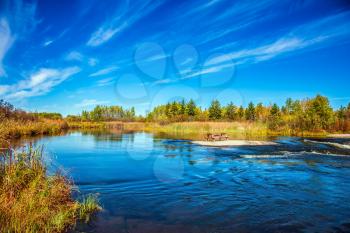  Thin cirrus clouds and broad Winnipeg River. Tranquil landscape in the Old Pinawa Dam Park. Trend of travel Around the World