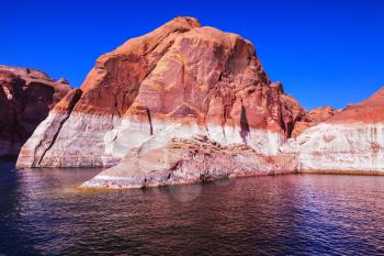  Lake Powell is surrounded by magnificent red hills. Walk on the boat at sunset. Scenic huge artificial water basin of the Colorado River, USA