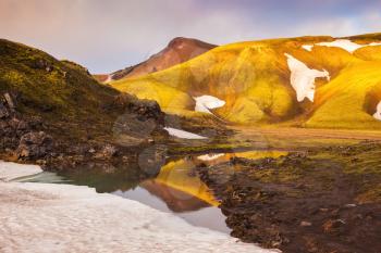 The golden light of dawn illuminates the mountains and glaciers national park Landmannalaugar, Iceland. Magic sunrise in the Arctic