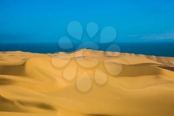 Atlantic coast of Namibia, south of Africa. Giant sand dunes on the ocean shore. The concept of exotic and extreme travel