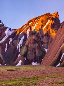  Mountains and glaciers covered with warm pink and orange sunlight. Morning dawn  National Park Landmannalaugar, Iceland