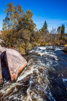 Foam water rapids on the smooth stones of the Winnipeg River. The concept of ecological and adventure tourism Warm clear autumn day