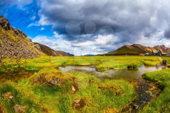 The picturesque valley in Landmannalaugar national park. July in Iceland. Green grass among hot springs
