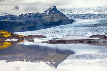 Glacier meltwater form a picturesque lake.  The sunset over the  Iceland's largest glacier Vatnajokull. The concept of extreme northern tourism